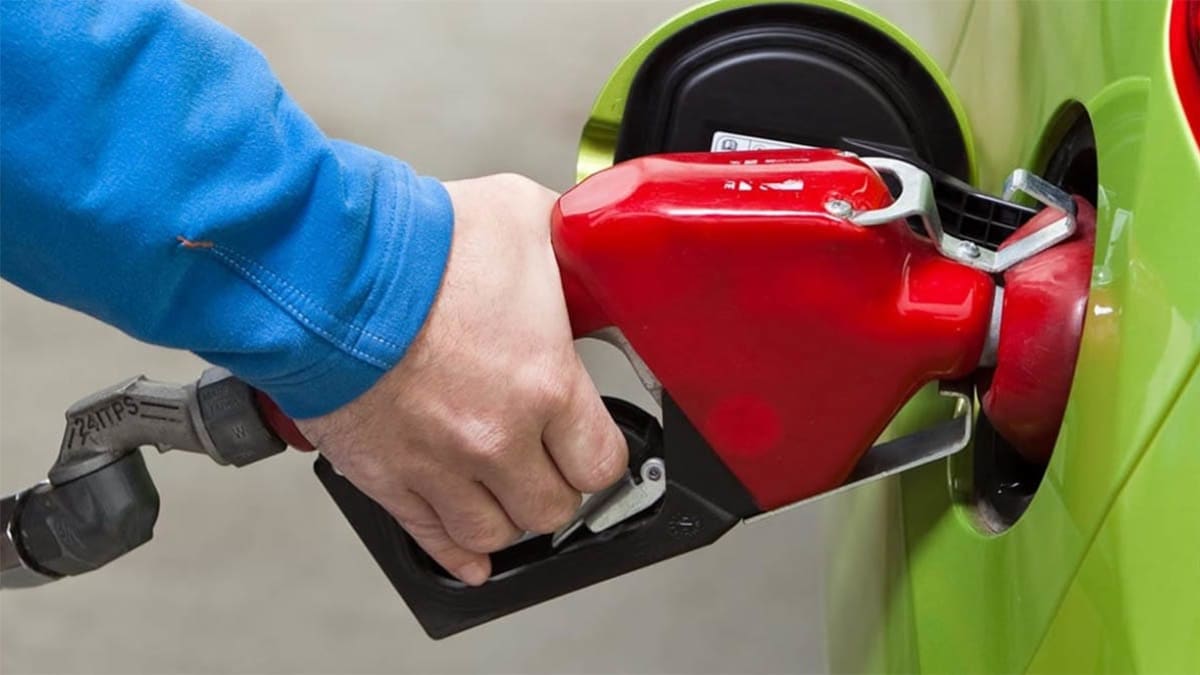 Person pumping gas into a lime green car.